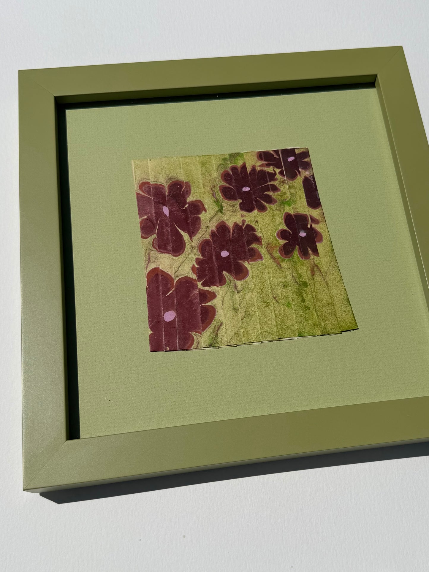Framed Ebru Pleat III by Morgan Elvington Walker — original marbling on pleated newsprint paper, 5×5 in, framed. Midnight Gallery.