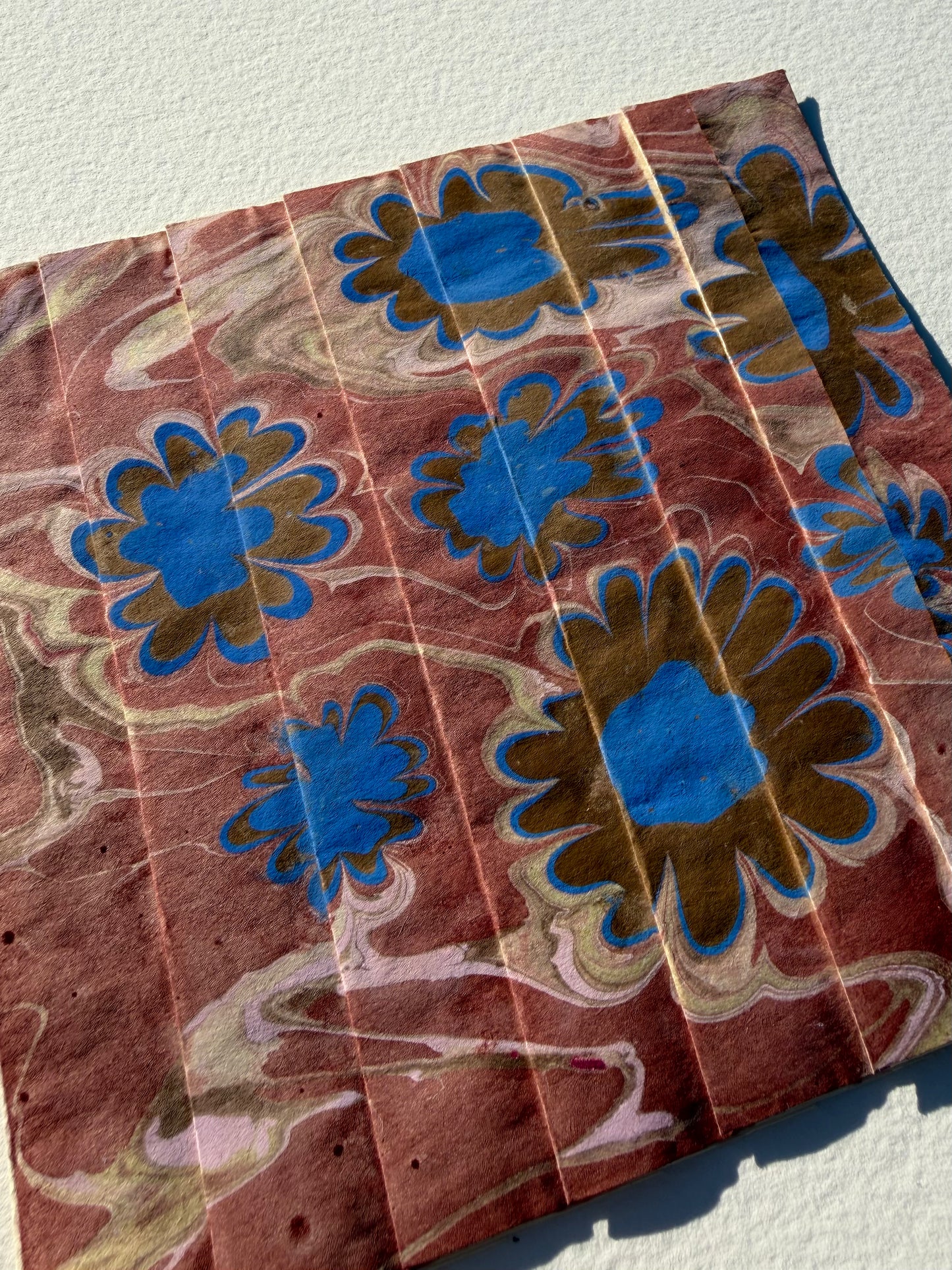 Ebru Pleat IV by Morgan Elvington Walker — original marbling on pleated newsprint paper, 6×6 in. Midnight Gallery.