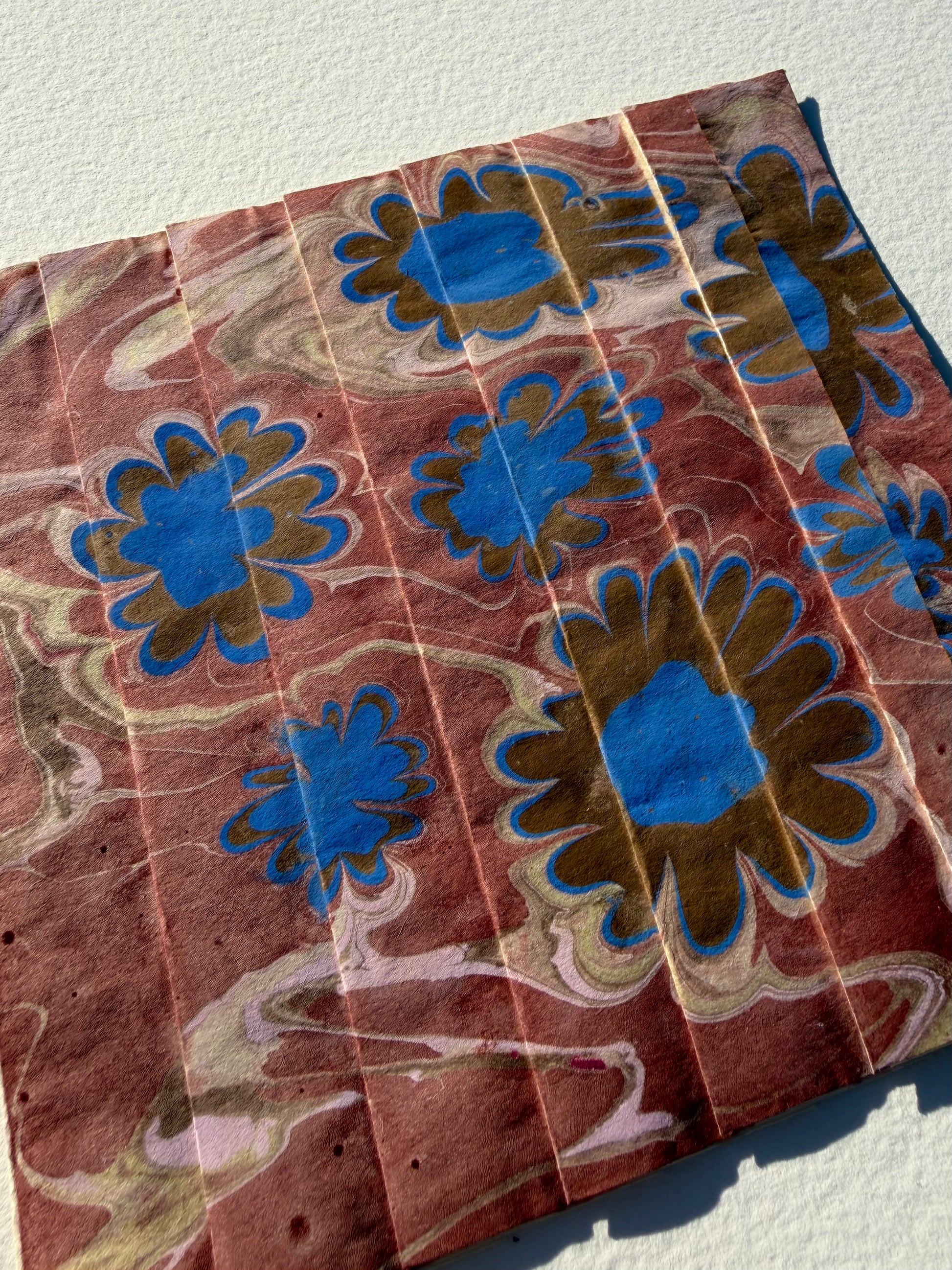 Ebru Pleat IV by Morgan Elvington Walker — original marbling on pleated newsprint paper, 6×6 in. Midnight Gallery.